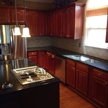 Traditional Dark ubatuba coutertops with cherry cabinets