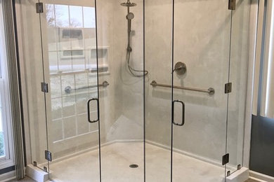 Large transitional marble tile ceramic tile and brown floor corner shower photo in Other with a hinged shower door