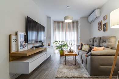 Ejemplo de sala de estar abierta escandinava pequeña con paredes blancas, suelo de baldosas de porcelana, televisor colgado en la pared, suelo gris y alfombra
