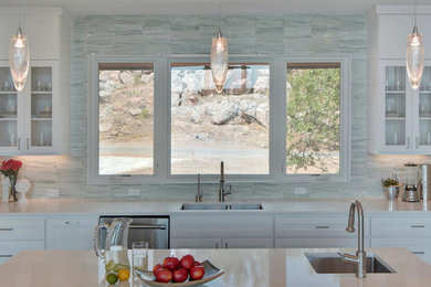 Example of a large trendy u-shaped porcelain tile and gray floor open concept kitchen design in Austin with an undermount sink, shaker cabinets, white cabinets, quartz countertops, white backsplash, stone tile backsplash, stainless steel appliances and an island