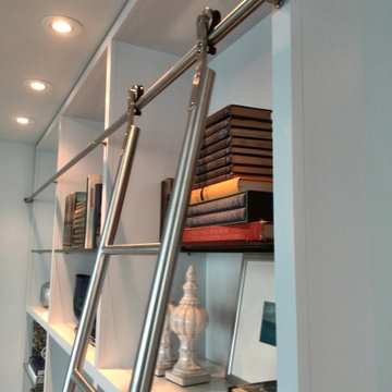 Built in library shelving with custom stainless steel rolling ladder