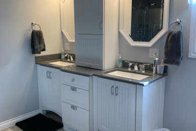 Example of a double-sink bathroom design in Other with white cabinets, gray walls and gray countertops
