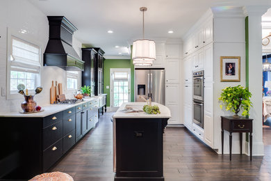 Inspiration for a large traditional u-shaped separate kitchen in Kansas City with a single-bowl sink, flat-panel cabinets, black cabinets, marble benchtops, white splashback, subway tile splashback, stainless steel appliances, dark hardwood floors and with island.