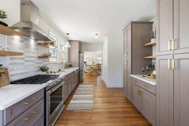 Photo of a medium sized classic galley enclosed kitchen in San Francisco with a submerged sink, recessed-panel cabinets, beige cabinets, engineered stone countertops, beige splashback, marble splashback, stainless steel appliances, light hardwood flooring, no island, beige floors and white worktops.