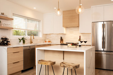 Trendy l-shaped medium tone wood floor and brown floor kitchen photo in Other with an undermount sink, flat-panel cabinets, white cabinets, beige backsplash, stainless steel appliances, white countertops and an island