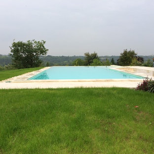 Idéer för att renovera en mycket stor funkis l-formad infinitypool framför huset, med naturstensplattor