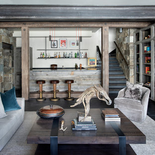 他の地域のモダンスタイルのおしゃれな地下室 (ベージュの壁、標準型暖炉、木材の暖炉まわり) の写真