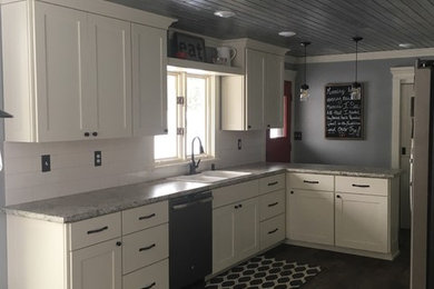 Mid-sized country galley dark wood floor and brown floor eat-in kitchen photo in Other with a double-bowl sink, shaker cabinets, white cabinets, granite countertops, white backsplash, ceramic backsplash, stainless steel appliances and a peninsula
