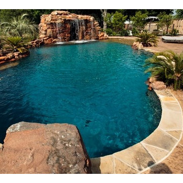 Lagoon style swimming pool with waterfall grotto with spa inside.
