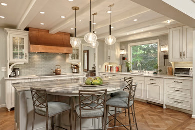 Example of a large classic medium tone wood floor and brown floor kitchen design in DC Metro with a single-bowl sink, white cabinets, quartzite countertops, gray backsplash, glass tile backsplash, paneled appliances, an island and beige countertops