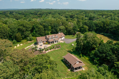 Example of a large classic brown two-story wood and shingle exterior home design in Providence with a shingle roof and a brown roof