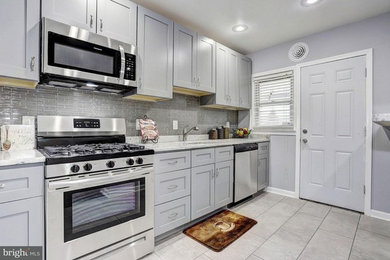 Example of a small classic ceramic tile and beige floor eat-in kitchen design in Baltimore with a drop-in sink, shaker cabinets, gray cabinets, granite countertops, gray backsplash, glass tile backsplash, stainless steel appliances and white countertops