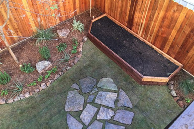 This is an example of a large contemporary drought-tolerant backyard stone vegetable garden landscape in Houston.