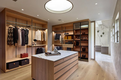 Minimalist gender-neutral medium tone wood floor dressing room photo in Philadelphia with glass-front cabinets and medium tone wood cabinets