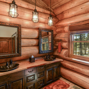 Mid-sized mountain style 3/4 light wood floor and brown floor bathroom photo in Boise with raised-panel cabinets, dark wood cabinets, brown walls, a vessel sink, wood countertops and red countertops