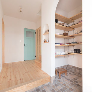 大阪のアジアンスタイルのおしゃれな玄関 (白い壁、グレーの床) の写真