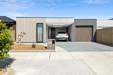 Modelo de fachada de casa gris de tamaño medio de una planta con revestimientos combinados, tejado plano y tejado de metal