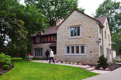 Mid-sized traditional beige two-story stone exterior home idea in Other