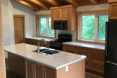 Small arts and crafts l-shaped laminate floor and gray floor eat-in kitchen photo in Vancouver with a drop-in sink, shaker cabinets, laminate countertops, black appliances, an island and white countertops