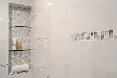 Bild på ett funkis en-suite badrum, med släta luckor, skåp i mörkt trä, en öppen dusch, en toalettstol med hel cisternkåpa, vit kakel, keramikplattor, grå väggar och klinkergolv i porslin