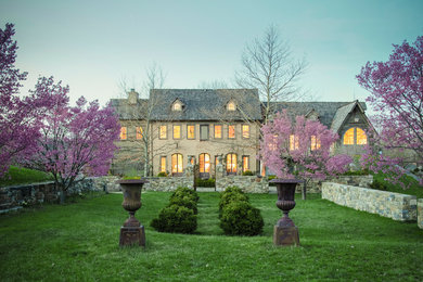 Huge farmhouse beige two-story stucco exterior home idea in New York with a hip roof