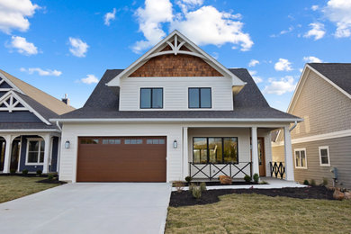Example of a large danish white two-story wood and clapboard house exterior design in Cincinnati with a shingle roof and a black roof
