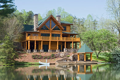 Example of a mountain style brown three-story wood house exterior design in Other with a hip roof and a shingle roof