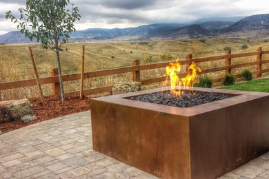 Example of a mid-sized minimalist backyard brick patio design in Denver with a fire pit and no cover