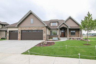 Inspiration for a large timeless beige split-level mixed siding exterior home remodel in Other with a shingle roof