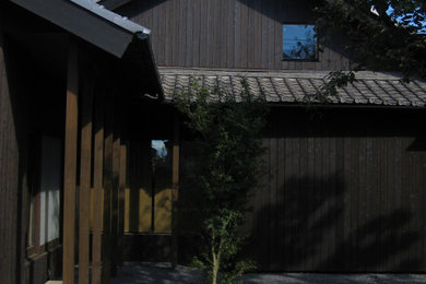 Imagen de fachada de casa negra y gris de estilo zen grande de dos plantas con revestimiento de madera, tejado a dos aguas, tejado de teja de barro y panel y listón