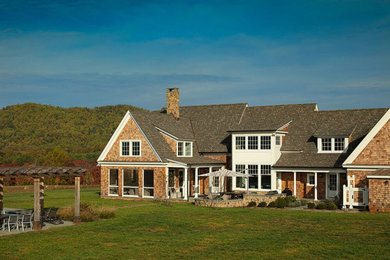 Huge transitional brown three-story wood and shingle exterior home idea in Other with a mixed material roof and a gray roof