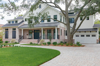 This is an example of a large country two-storey white house exterior in Houston with mixed siding, a gable roof and a shingle roof.