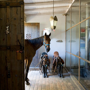 Ispirazione per un corridoio country di medie dimensioni con pareti bianche, pavimento in mattoni, una porta a due ante e una porta in legno scuro