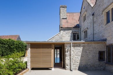 This is an example of a contemporary side house exterior in Other with stone cladding and a mixed material roof.