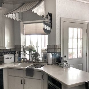 Ispirazione per una grande cucina country con paraspruzzi in travertino, elettrodomestici neri, parquet chiaro, isola, pavimento bianco, top grigio, lavello a doppia vasca, ante bianche, top in cemento e paraspruzzi grigio