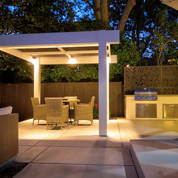 Evening Ambiance: Illuminated Pergola, Outdoor Kitchen, and Seating Area