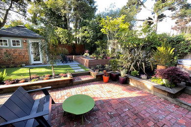 Ejemplo de jardín contemporáneo pequeño en patio trasero con macetero elevado, exposición parcial al sol y adoquines de piedra natural