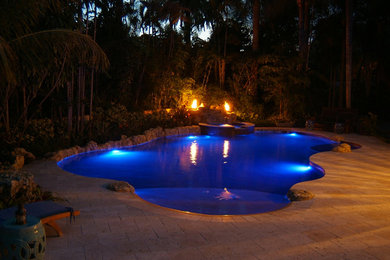 Inspiration for a mid-sized backyard stone and custom-shaped natural hot tub remodel in Miami