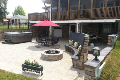 Inspiration for a large rustic backyard stone patio remodel in Other with a fire pit and no cover