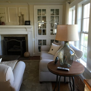 Idee per un piccolo soggiorno country aperto con pavimento in legno massello medio, TV a parete, pareti gialle, camino classico e cornice del camino in intonaco