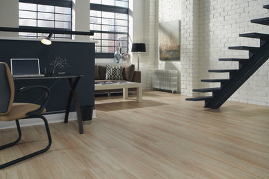 Example of a minimalist light wood floor home office design in Other