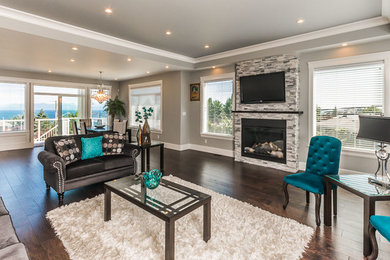 Living room - large contemporary open concept dark wood floor and brown floor living room idea in Vancouver with gray walls, a standard fireplace, a stone fireplace and a wall-mounted tv