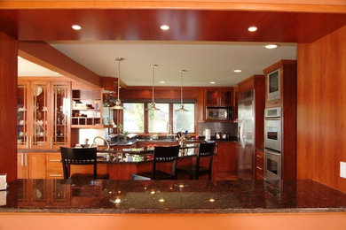 Inspiration for a large modern l-shaped open concept kitchen remodel in Toronto with granite countertops, an undermount sink, shaker cabinets, medium tone wood cabinets, multicolored backsplash, stone slab backsplash, stainless steel appliances and an island