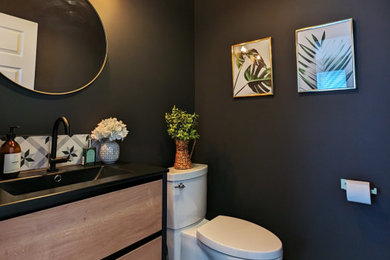 Design ideas for a small contemporary kids bathroom in Montreal with medium wood cabinets, a one-piece toilet, black and white tile, porcelain tile, porcelain floors, an integrated sink, solid surface benchtops, multi-coloured floor, black benchtops, a single vanity and a floating vanity.