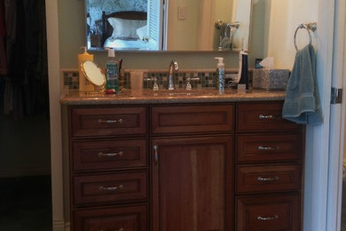 Inspiration for a small timeless master brown tile and porcelain tile bathroom remodel in Las Vegas with raised-panel cabinets, medium tone wood cabinets and granite countertops