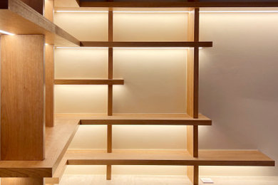 Réalisation d'un bureau design de taille moyenne avec une bibliothèque ou un coin lecture, un mur beige, un sol en bois brun, un bureau indépendant et un sol beige.