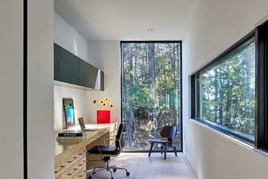Study room - contemporary built-in desk light wood floor study room idea in DC Metro with white walls