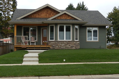 Small arts and crafts green one-story vinyl exterior home photo in Calgary with a shingle roof