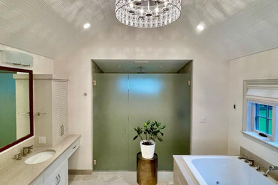 Photo of a large traditional ensuite bathroom in Portland with louvered cabinets, white cabinets, a built-in bath, a built-in shower, a bidet, beige tiles, porcelain tiles, beige walls, porcelain flooring, a submerged sink, granite worktops, beige floors, a hinged door, beige worktops, a wall niche, double sinks, a built in vanity unit and a vaulted ceiling.