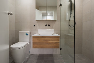 Design ideas for a mid-sized contemporary master bathroom in Sydney with flat-panel cabinets, light wood cabinets, an open shower, beige tile, ceramic tile, quartzite benchtops, grey floor, an open shower, white benchtops, a single vanity and a floating vanity.
